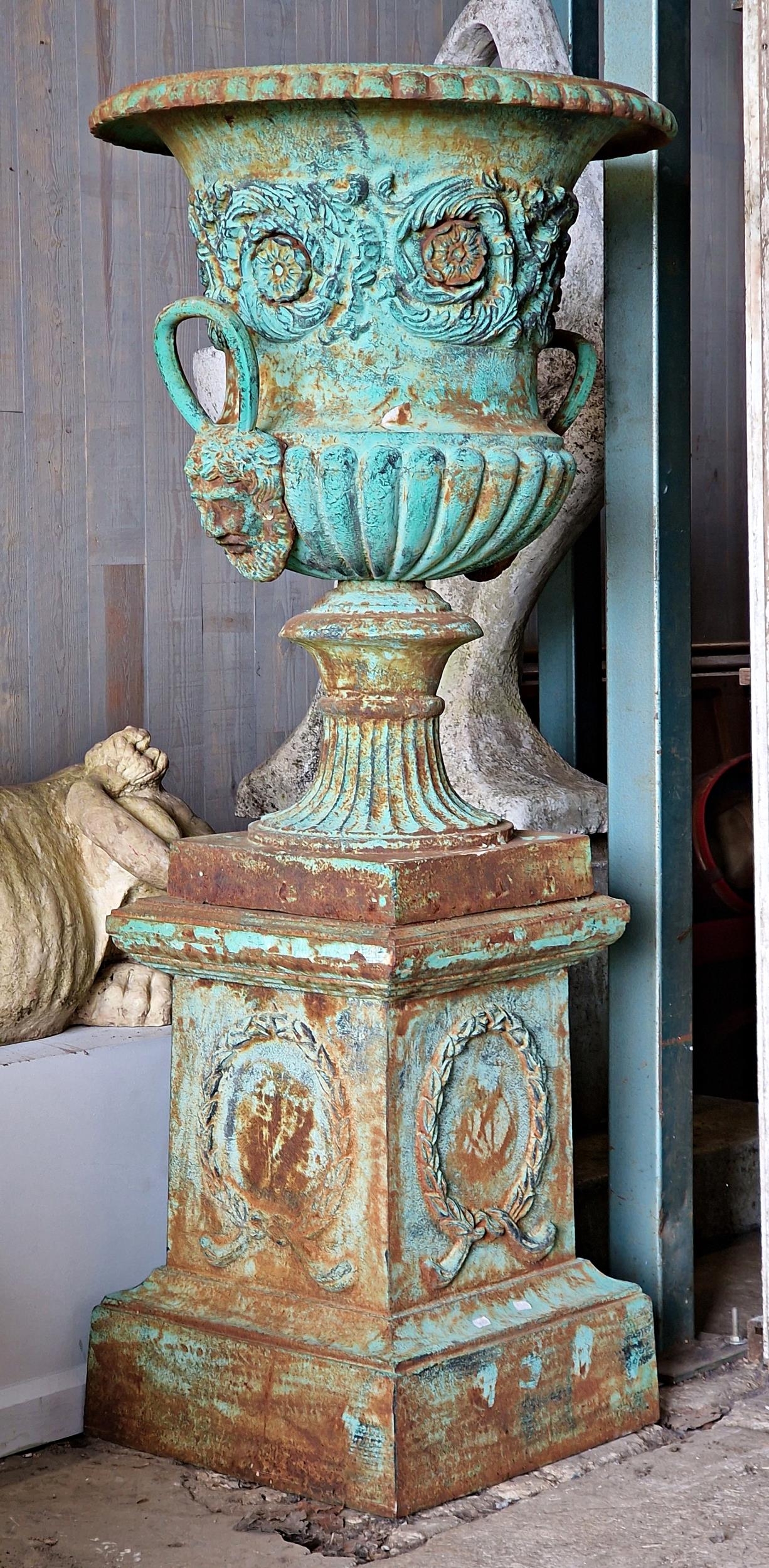 An impressive classical style cast iron Campana shaped garden urn with lobed bowl and twin mask loop