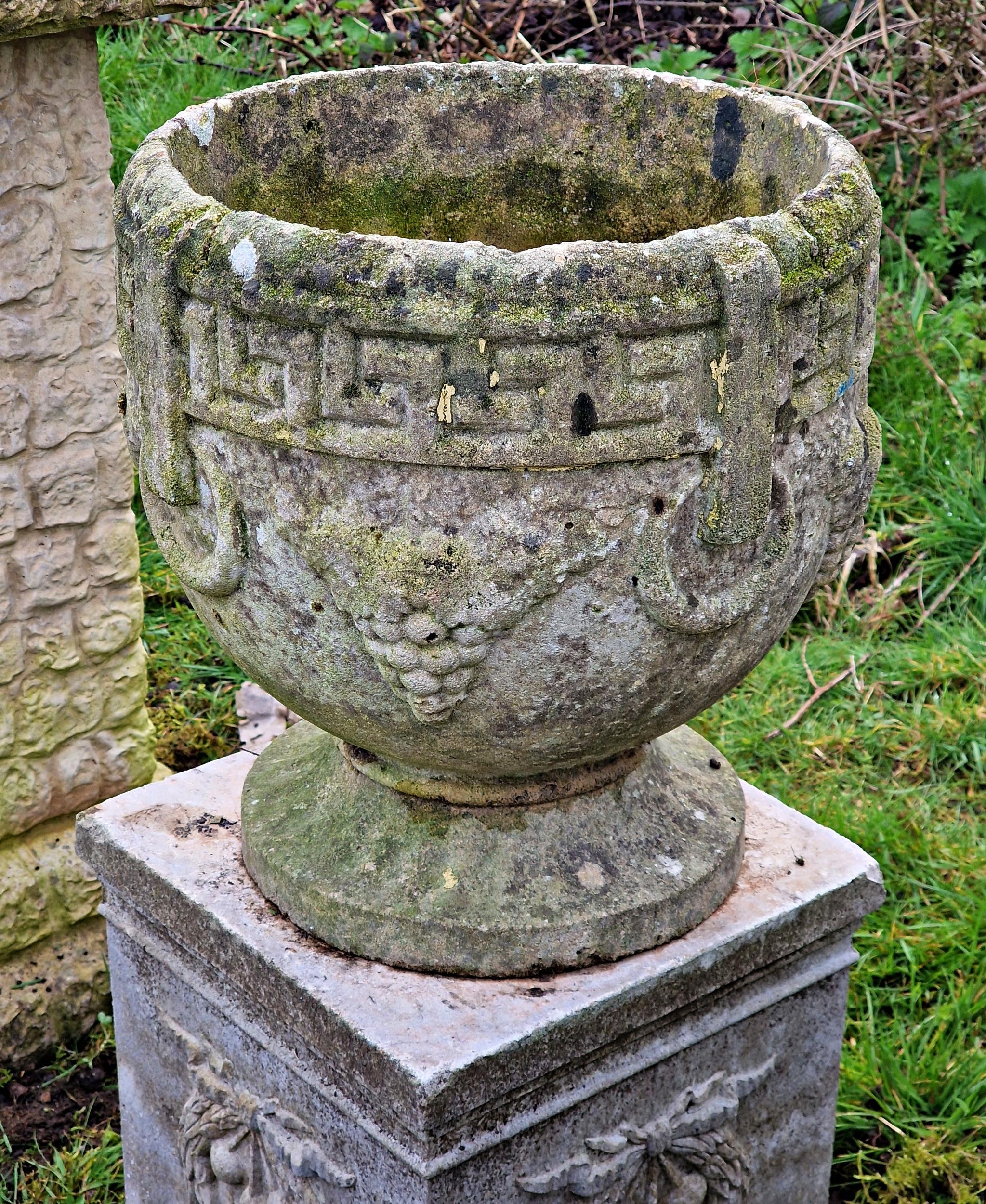 A pair of weathered reconstituted stone garden urns with Greek Key and grape detail raised on - Image 2 of 2