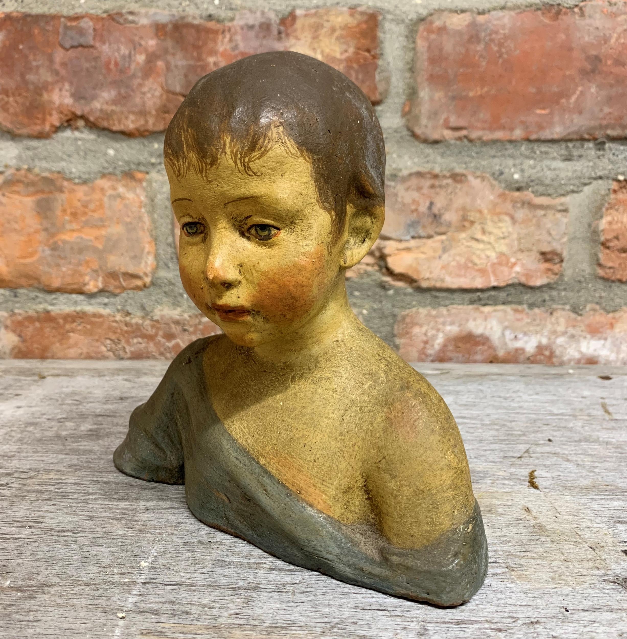 Early 20th century painted terracotta bust of a young boy, unsigned, 16cm high