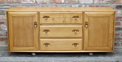 Ercol light elm sideboard fitted with three draws flanked by two cupboard doors, H 69cm x W 156cm