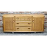 Ercol light elm sideboard fitted with three draws flanked by two cupboard doors, H 69cm x W 156cm