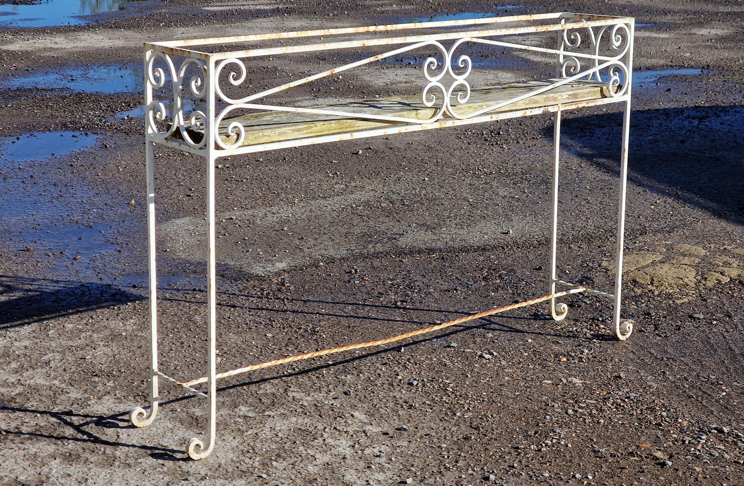A painted wrought iron plant stand with scroll work detail, H 71cm x W 106cm x D 21cm