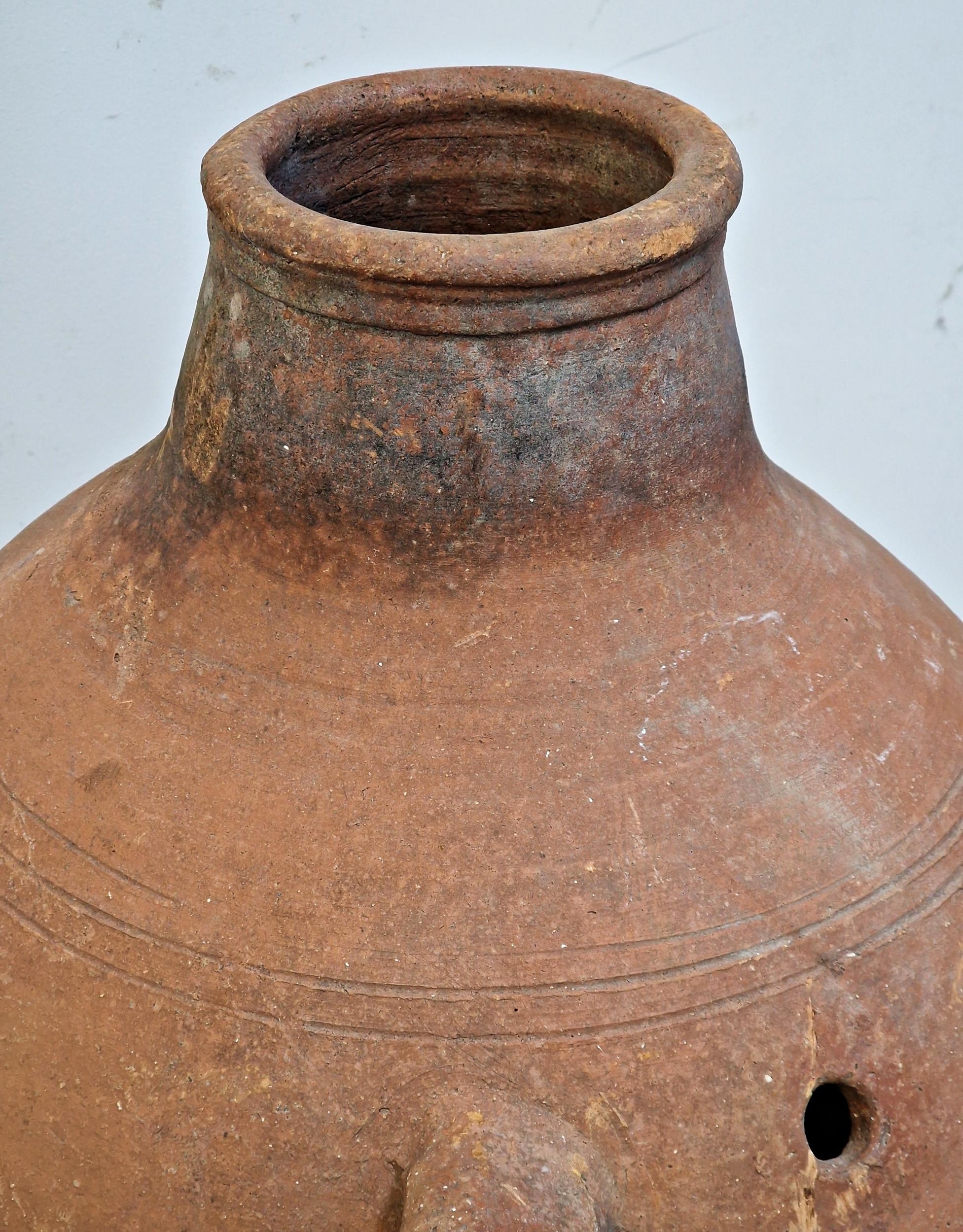 A terracotta amphora with twin loop handles and incised detail, raised on a wrought iron stand, H - Image 2 of 2