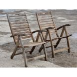 A pair of folding teak garden armchairs, H 100cm (2)