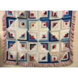 Victorian quilted bed cover with log cabin style cotton printed panels having a later pink frilled