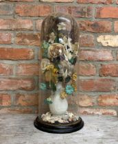 Victorian diorama of fabric flowers in a bisque baluster vase on a bed of shells, under a good