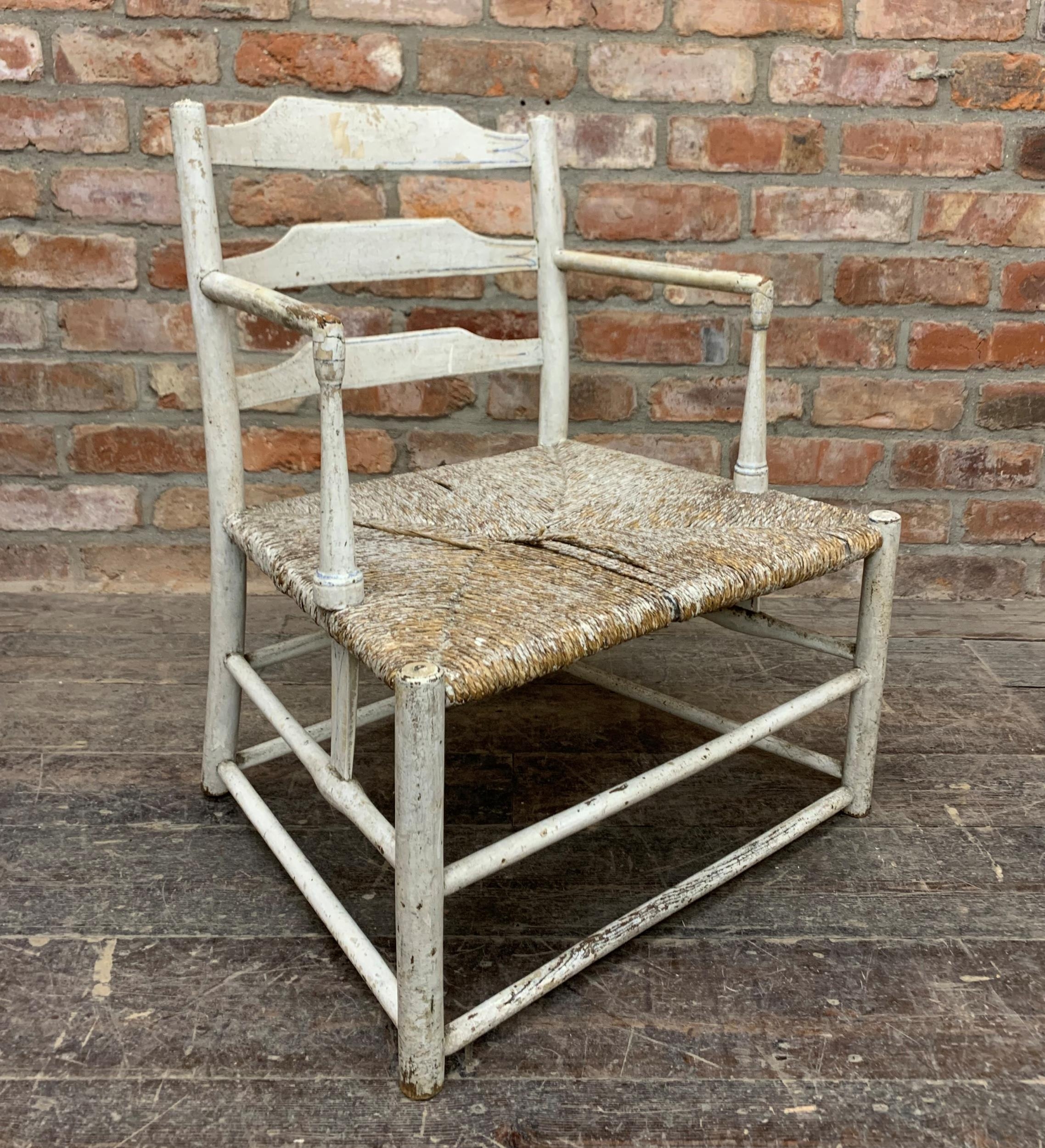 Good early Scandinavian primitive low nursing chair with painted ladder back and cord strung seat