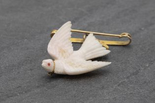 Unusual 9ct bar brooch with carved white coral dove with gem set eye, 6cm high in total