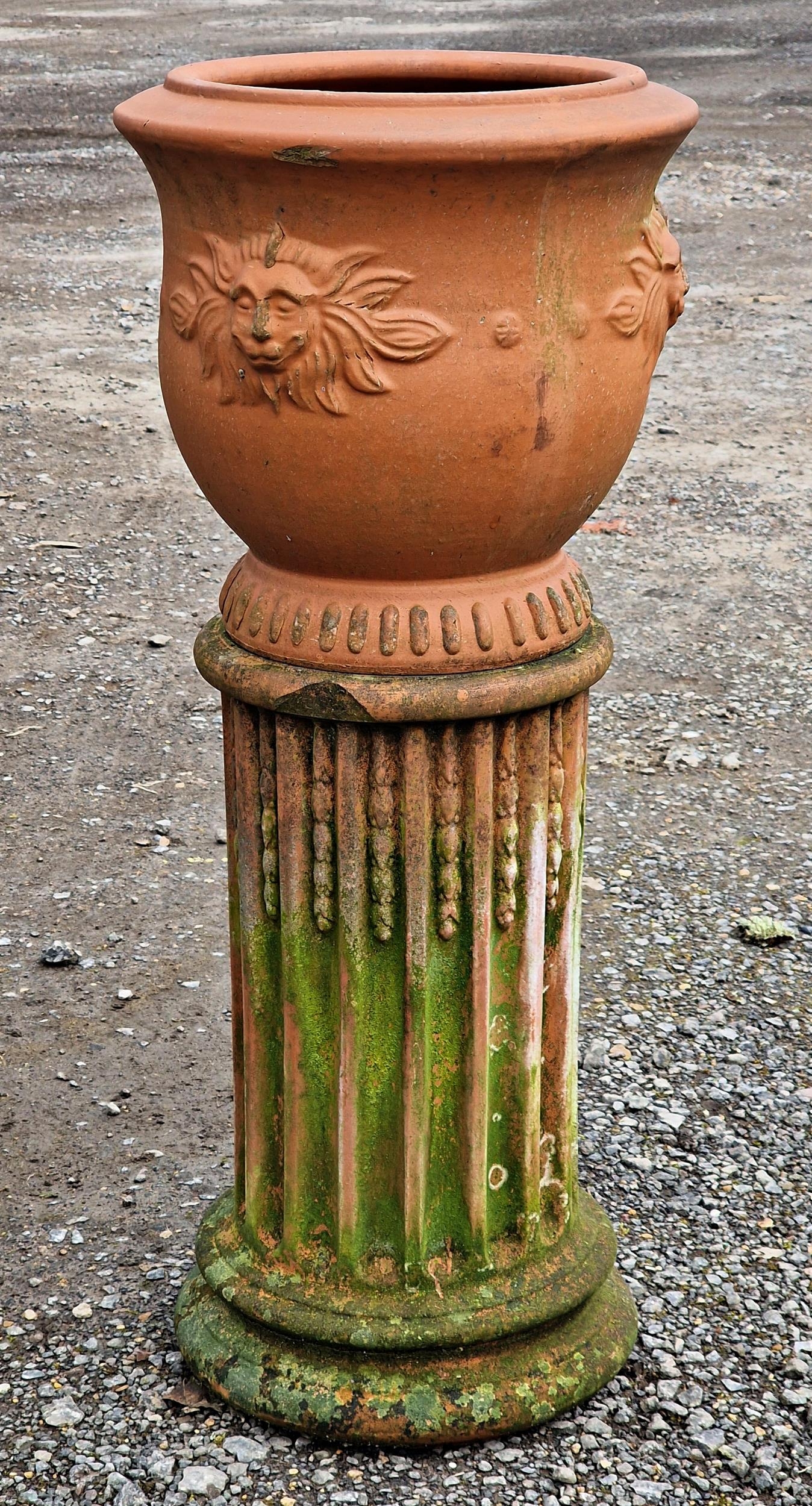 French terracotta urn with lions mask detail raised on a fluted terracotta pedestal, H 82cm x DIA