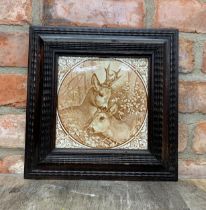 Large Victorian Aesthetic period ceramic tile of deers in carved wooden frame, H 31cm x W 31cm