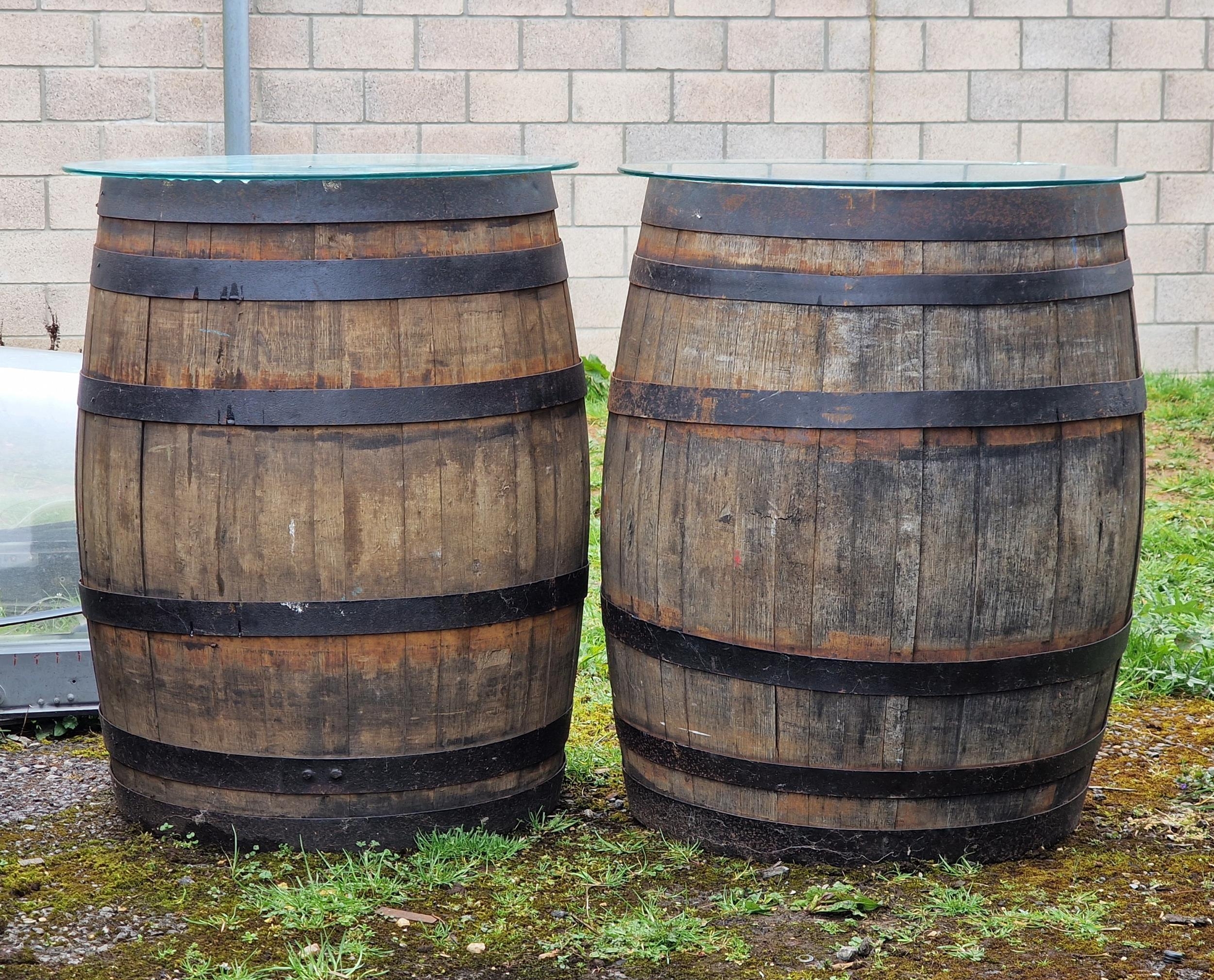 A pair of vintage wrought iron bound coopered oak barrels with glass tops, H 87cm x W 65cm approx (