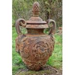 A good quality ornate cast iron garden urn with rams head handles, pineapple finial and foliate