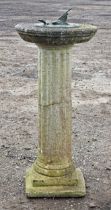 A reconstituted stone sundial with butterfly mount raised on a fluted column base, H 72cm