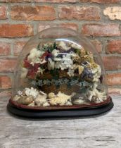 Unusual diorama of a knitted wirework floral diorama in a wicker basket on a bed of shells, under