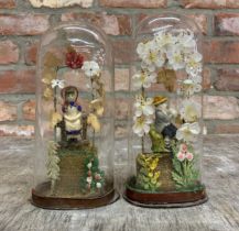 Pair of hand carved wax figures depicting children under floral bouquet, held within original
