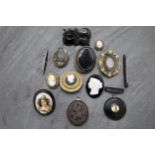 Twelve pieces of mourning jewellery to include four cameos, pique crescent brooch