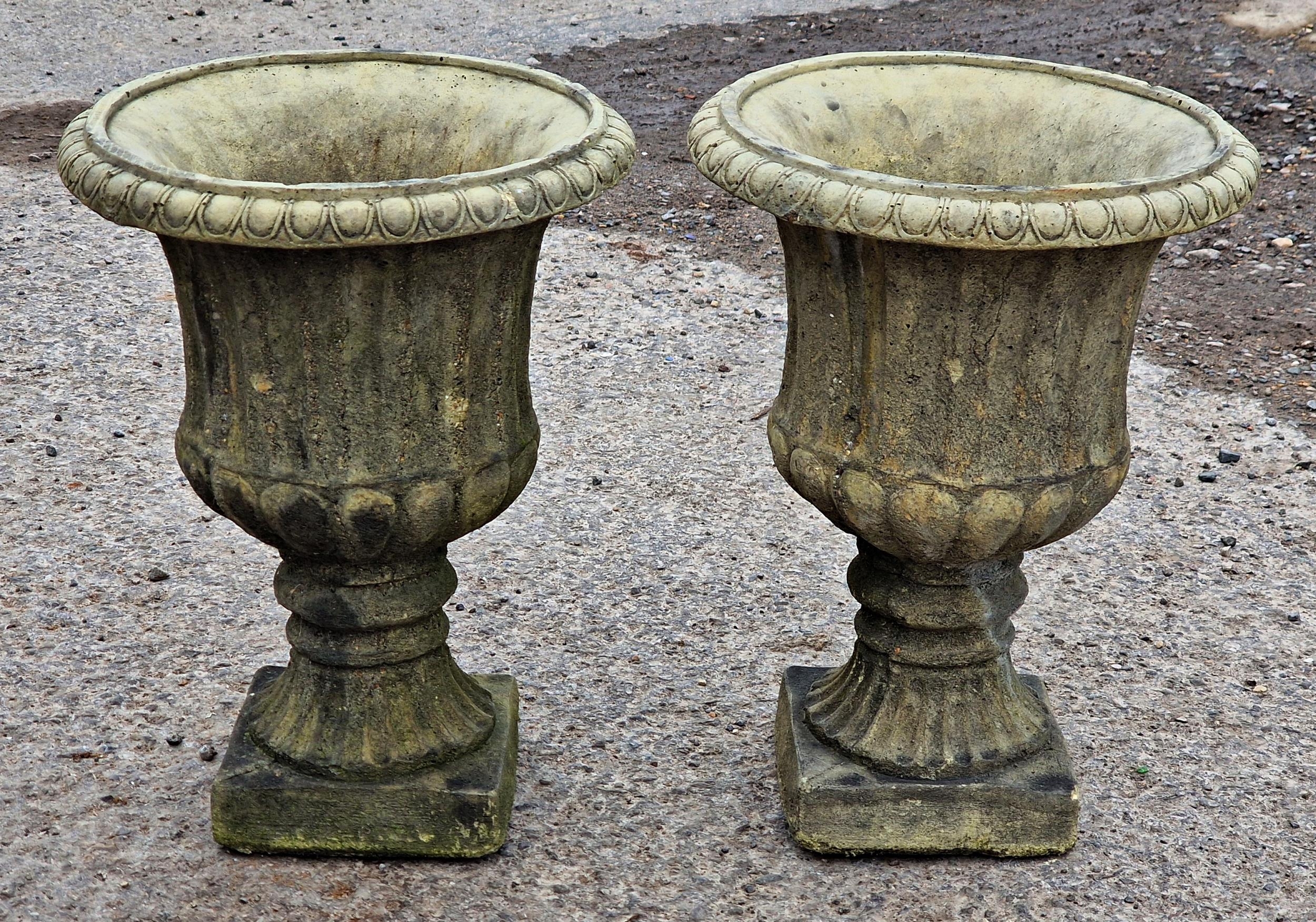 Pair of reconstituted stone Campana shaped garden urns with lobed bowls and flared egg and dart