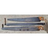 Two large Victorian twin handled saws, together with further large Victorian example, largest L