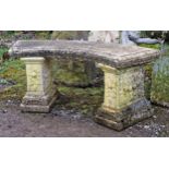 Weathered reconstituted stone three piece garden bench with curved moulded top raised on stepped