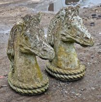 Pair of weathered reconstituted stone garden ornaments in the form of horse heads, H 49cm (2)