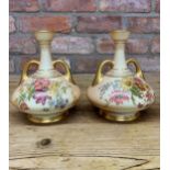 Pair of Royal Worcester hand painted blush ivory twin handled vases with floral finish throughout,