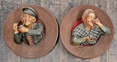 Pair of large composite plaster black Forest busts of husband and wife with pipe and snuff,