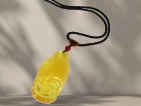 Kette/Collier: Stoffband mit schönem geschnitzten Bernstein-Anhänger, "Buddha"