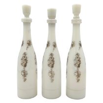 THREE WHITE OPALINE BOTTLES WITH STOPPERS