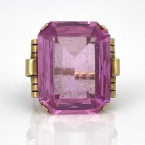 A yellow gold ring, set emerald-cut pink stone, (possibly synthetic)