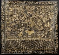 A Chinese gold bullion work panel, depicting an exotic bird amongst foliage, black silk ground, 29