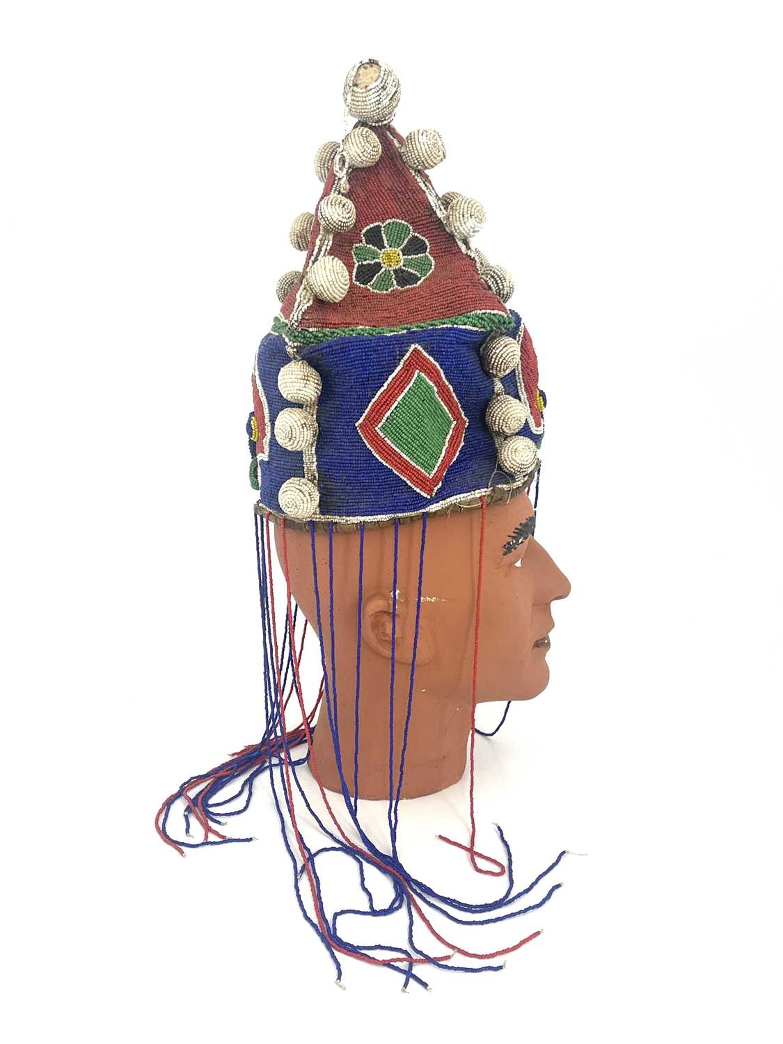 An African tribal beaded headdress, pyramidal form with bobbles and tassels, 30cm high