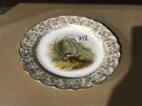 A Royal Worcester Vitreous China plate painted with grouse and chicks amongst grasses and reeds