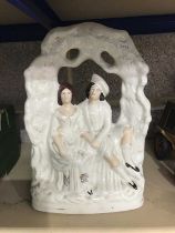 A Staffordshire flat back figure group, modelled as a courting couple, 34cm high