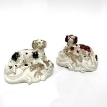 A pair of Staffordshire inkwells, modelled as Spaniels with retrieved game on scrollwork moulded