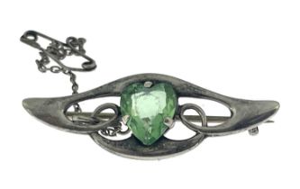 An Arts and Crafts silver and green stone set brooch, the central heart shaped gem within a winged