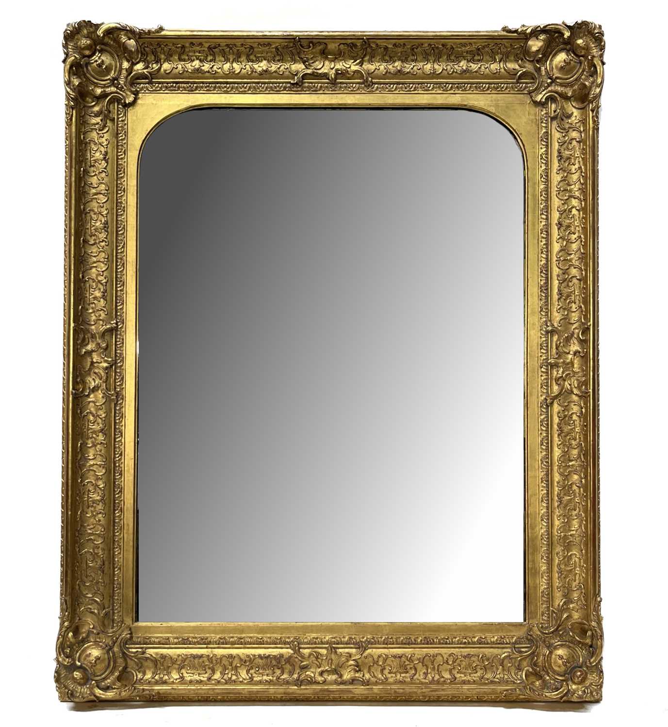 A large rectangular gilt framed wall mirror, late 19th Century, arched plate, fillet, Rococo