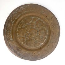 An Arts and Crafts copper charger, embossed and reticulated with sunflower design within a leaf