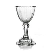 A pedestal sweetmeat glass or goblet, circa 1750, the rounded bowl with facet cut rim and cut