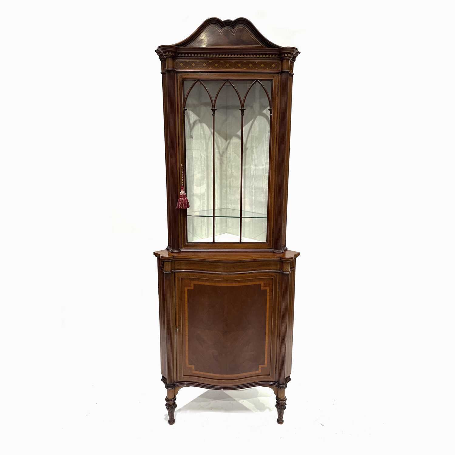 An Edwardian mahogany corner standing vitrine, circa 1910, arched pediment, crossbanded, marquetry