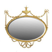 An oval gilt framed wall mirror, 19th Century, classical urn and garland pediment, bevelled plate,