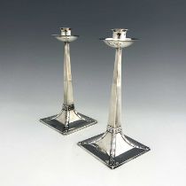 After Jan Eisenloeffel, a pair of Arts and Crafts silver candlesticks, James Ramsay/James Dixon,