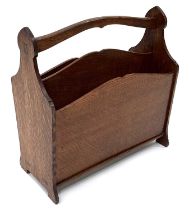 Arthur Simpson of Kendal, an Arts and Crafts carved oak magazine rack, the spade pointed Gothic arch