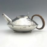 Archibald Knox for Liberty and Co., a Tudric pewter teapot, 0231, squat form with rattan handle