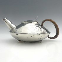 Archibald Knox for Liberty and Co., a Tudric pewter teapot, 0231, squat form with rattan handle