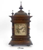 A Black Forest oak bracket clock, late 19th Century, of Germanic architectural form with finials,