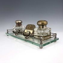 An Art Nouveau silver plated and glass desk stand, probably American, the rectangular glass platform