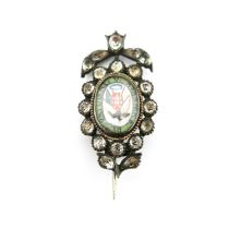 An early 19th century paste and silver brooch, the central rock crystal cabochon painted to the