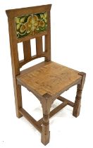 An Arts and Crafts oak and tile chair, possibly Leonard Wyburd for Liberty and Co., turned and