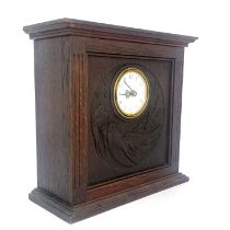 An Arts and Crafts Glasgow School carved oak clock, cuboid form with fluted columns flanking a