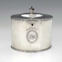 A George III silver neoclassical tea caddy, of drum shape with urn form finial, the exterior with